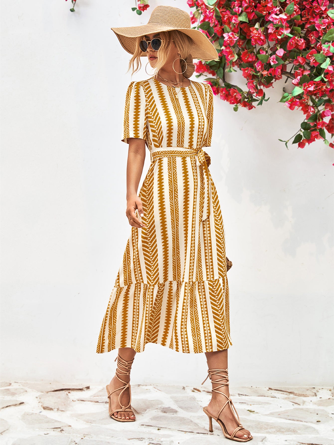 Gold striped round-neck puff sleeve dress with tied waist belt, front view with hat.