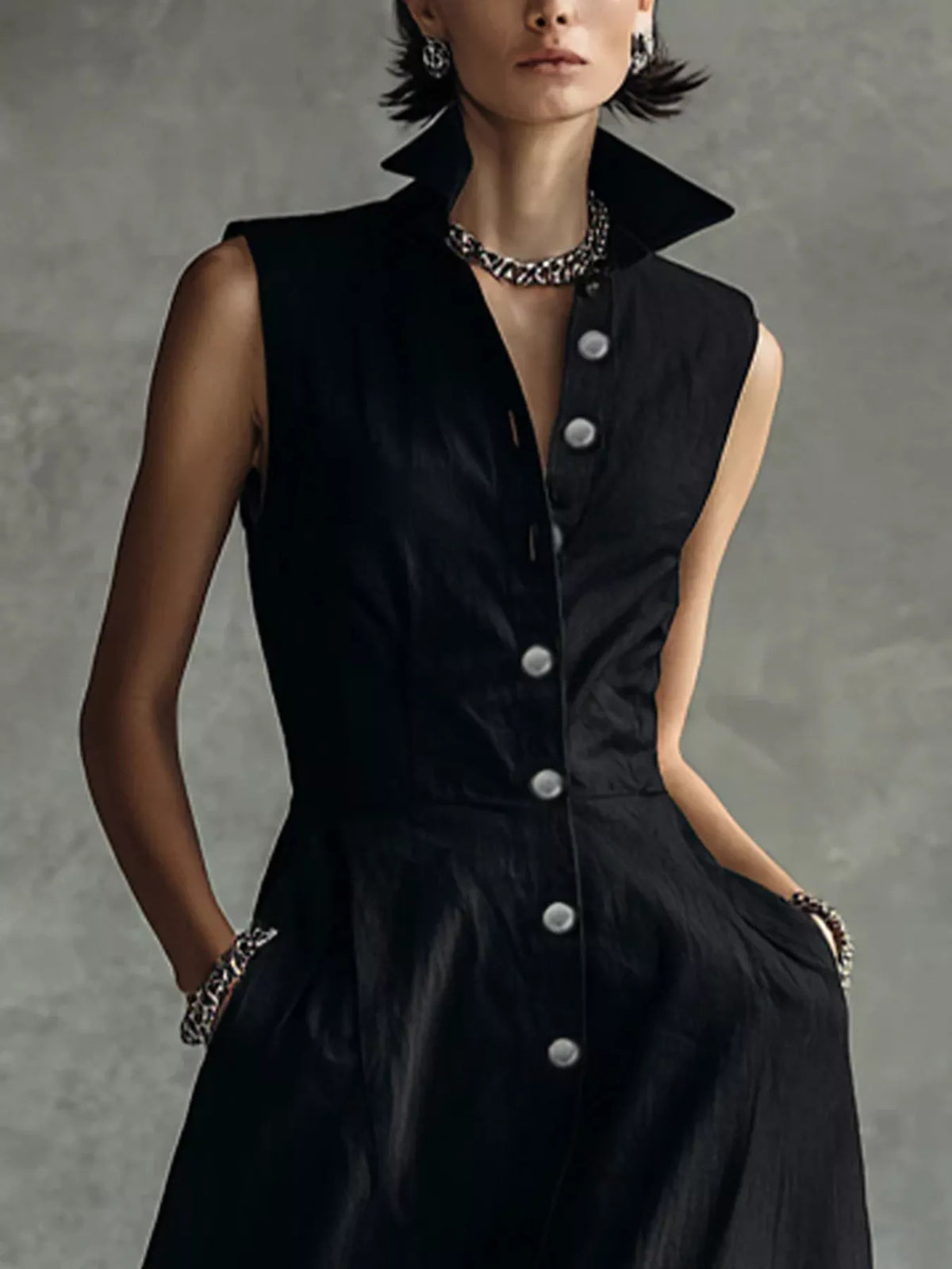 Black sleeveless button shirt dress with pointed collar, front placket, and round buttons.