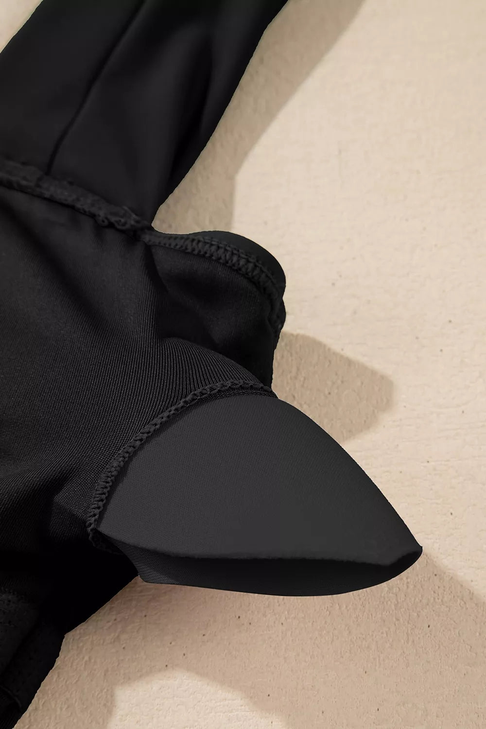 Black ruched tummy-control one-piece with gathered side waist detail