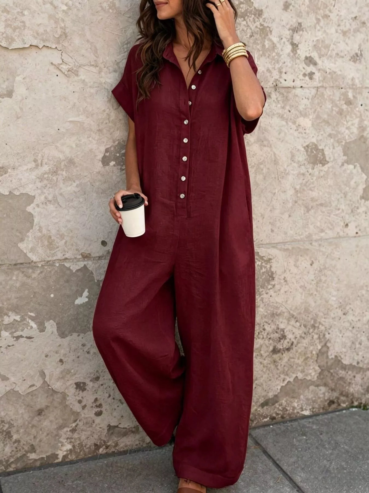 Burgundy button-front short-sleeve jumpsuit with wide-leg silhouette and pockets
