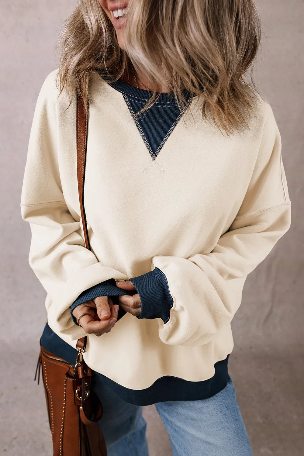 Ivory long-sleeve sweatshirt with contrast V yoke and ribbed dark waistband