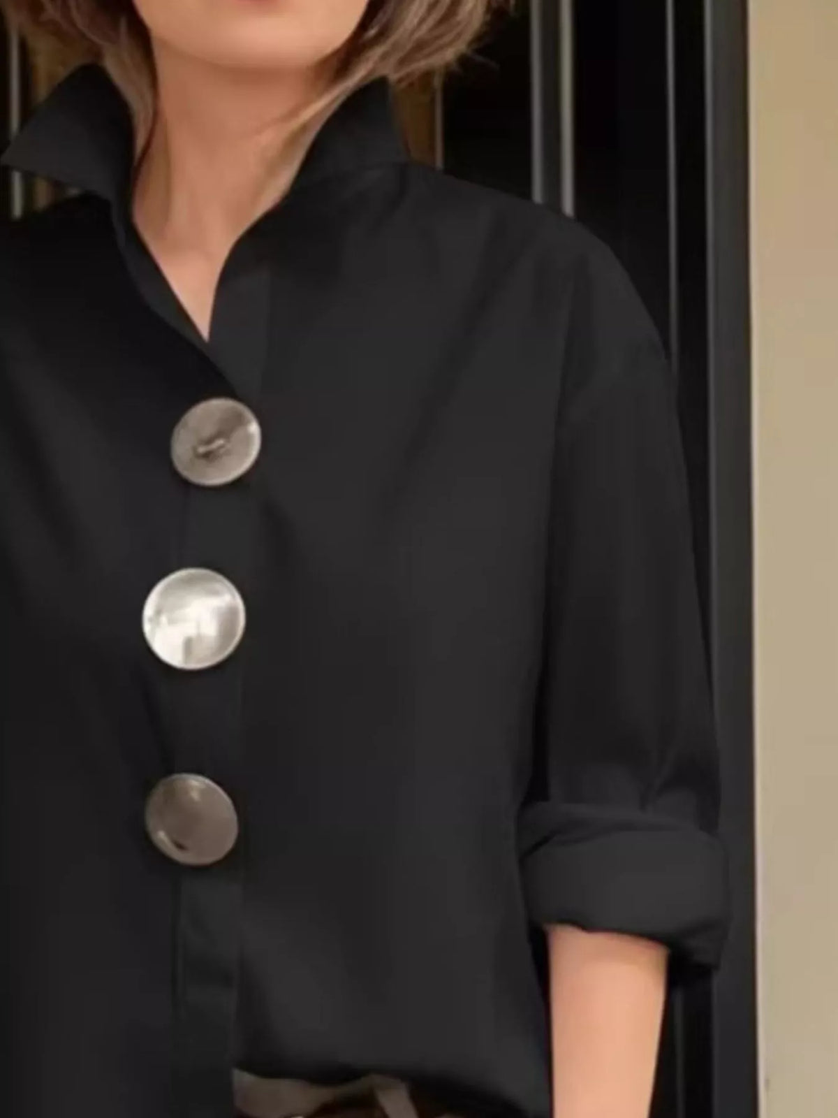 Black long-sleeve button shirt with metallic round buttons and point collar, chest view