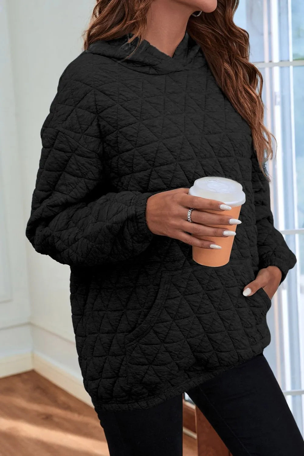 Black quilted long-sleeve hoodie with hood and front pocket