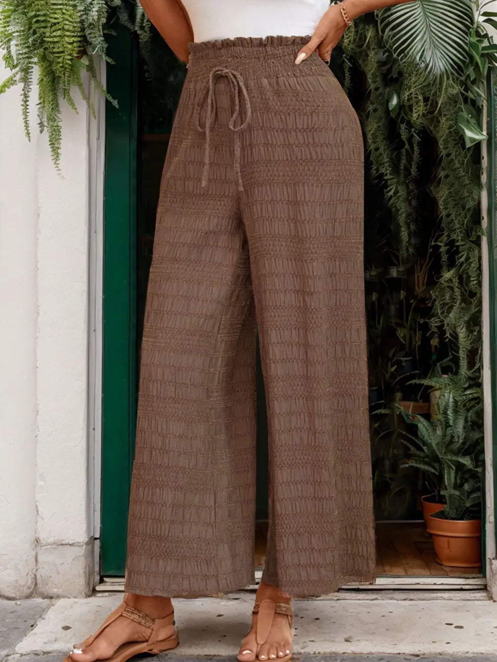 Brown wide-leg pants with gathered elastic waist and tied drawstring, textured