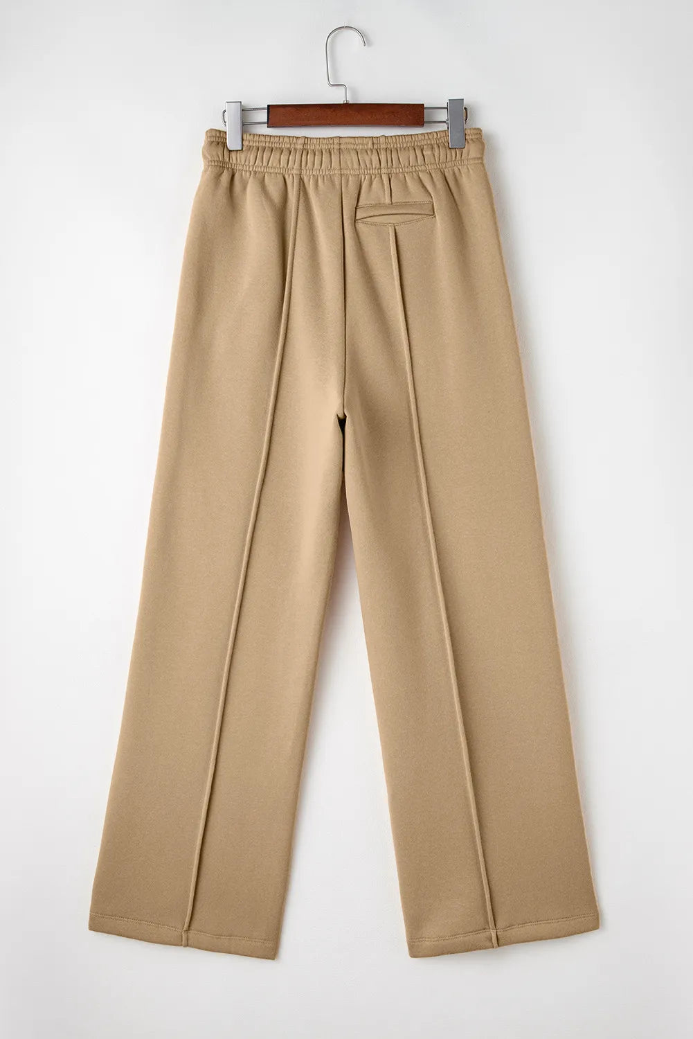 Tan wide-leg drawstring pants on hanger, back view with back seams