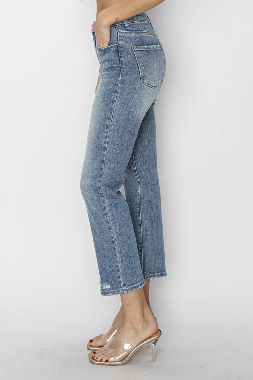 High-waist medium-wash cropped jeans with front distressing and knee seam detail.