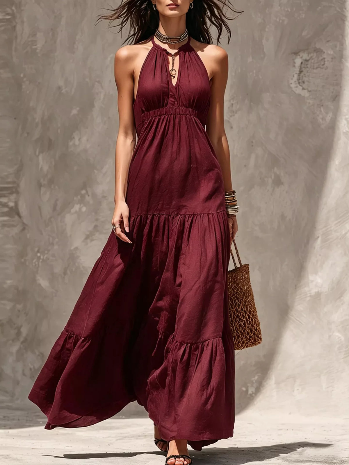Burgundy halter tiered maxi dress with gathered bodice and flowing layered skirt.