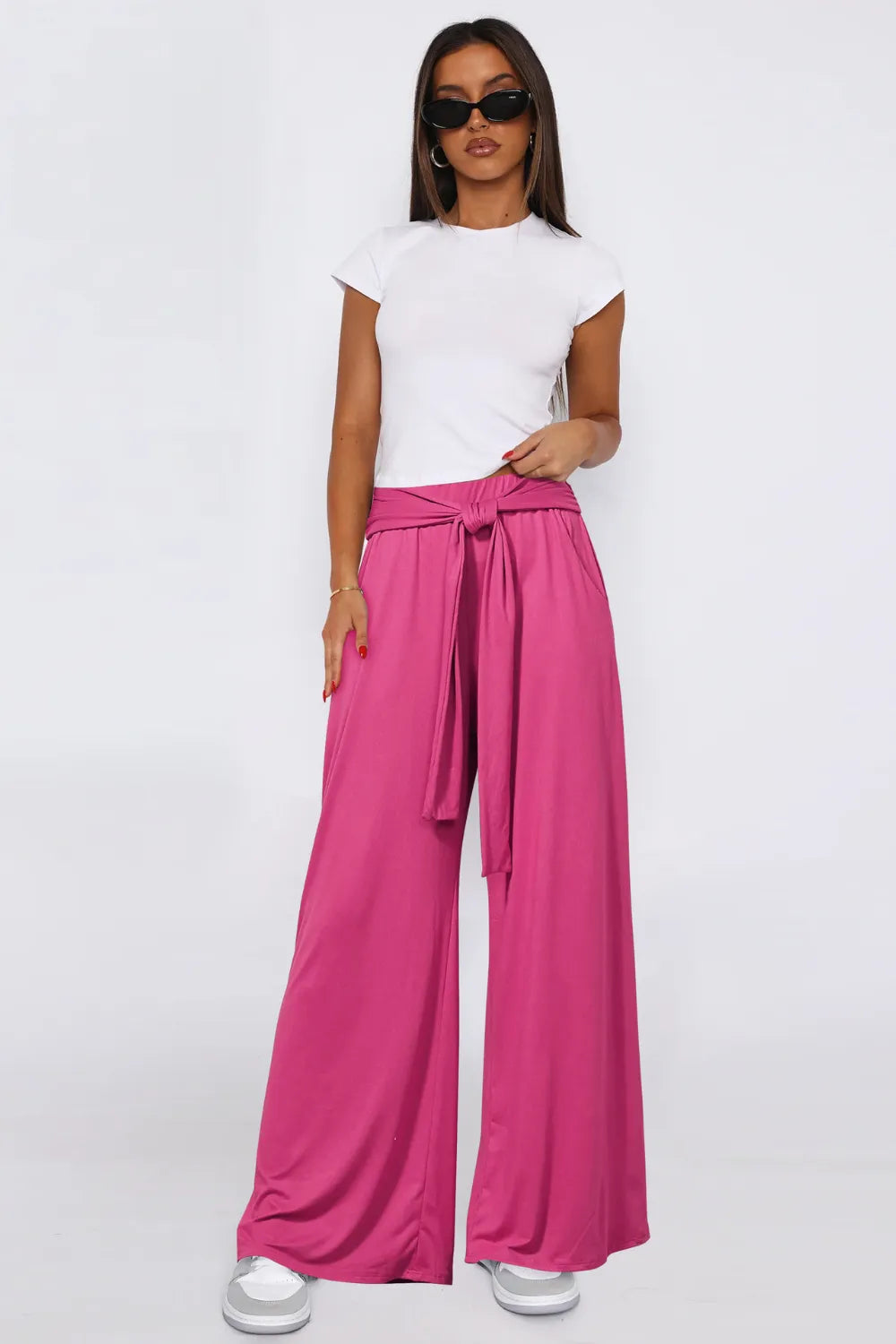 Hot pink wide-leg pants with tied waist and side pockets, flowy wide legs.