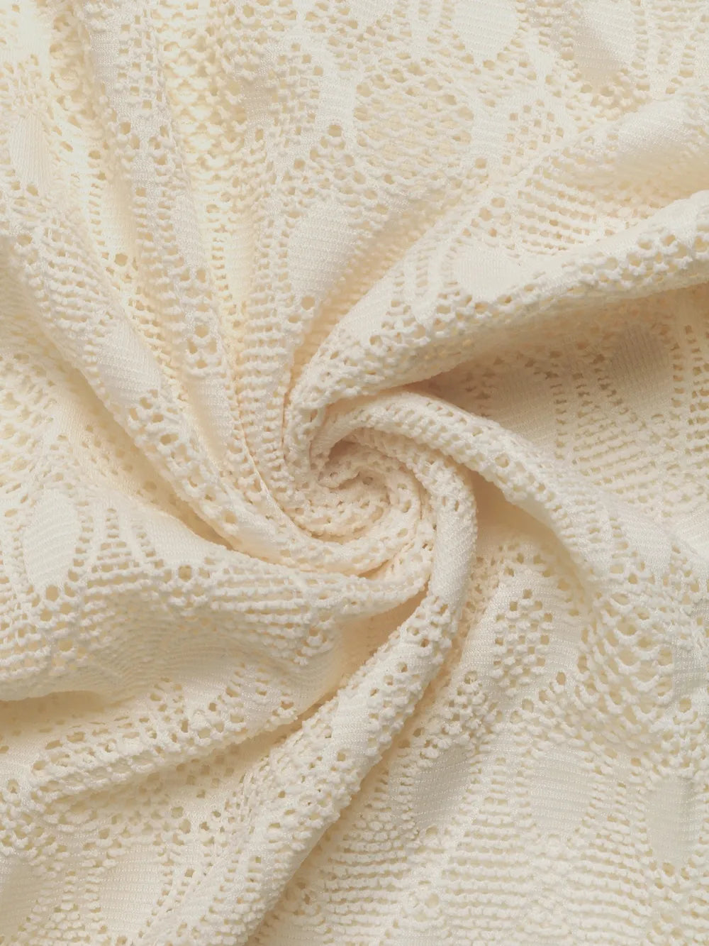 Cream lace fabric with textured openwork geometric pattern and soft drape