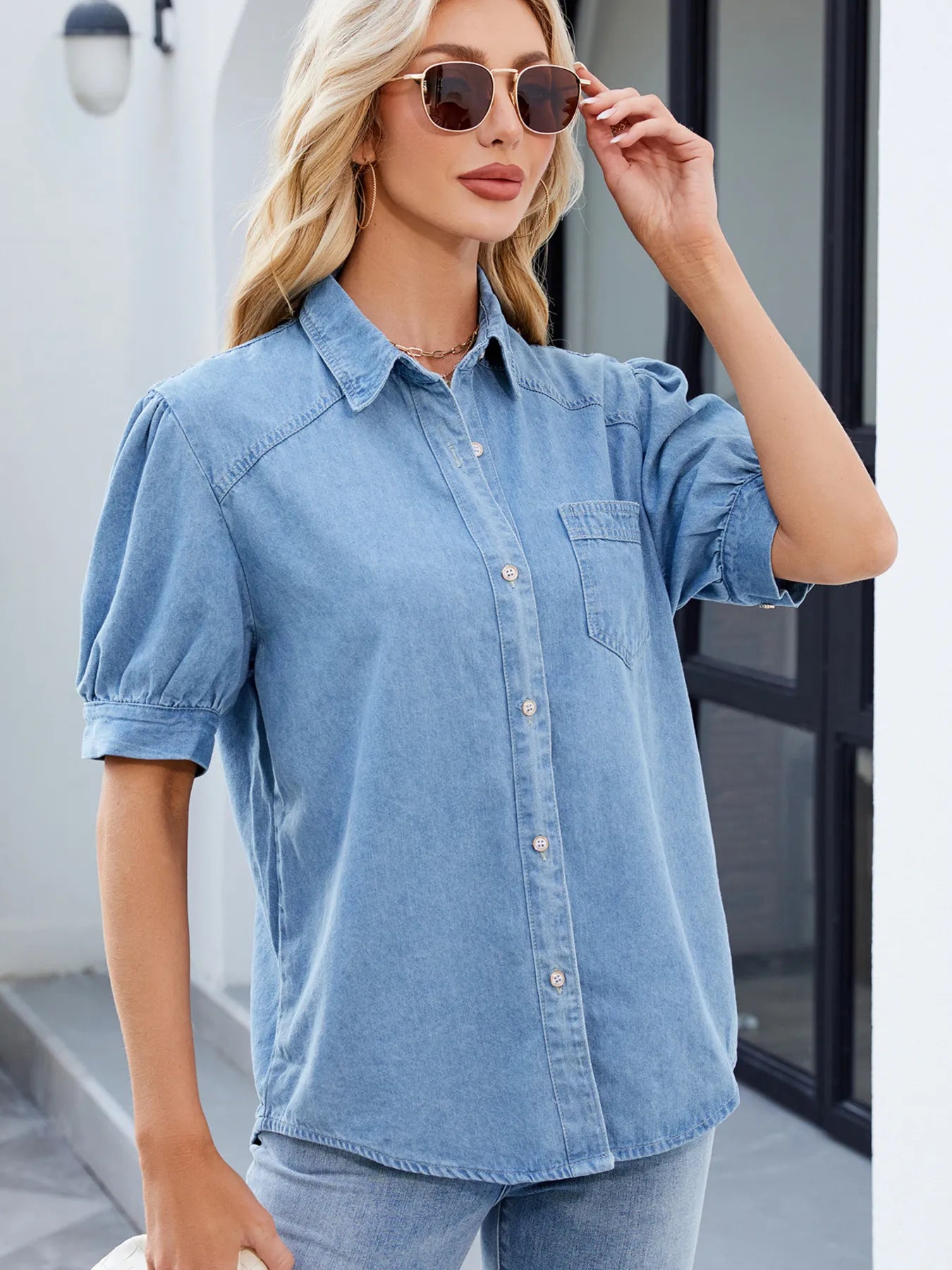 Light blue denim button-up short sleeve shirt with collared neckline and button placket