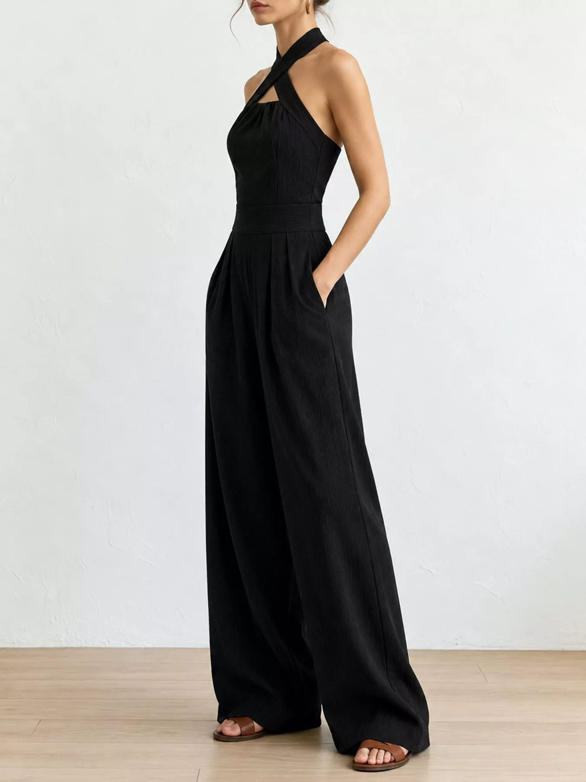 Black linen halter wide-leg jumpsuit side view with flowing wide pant legs