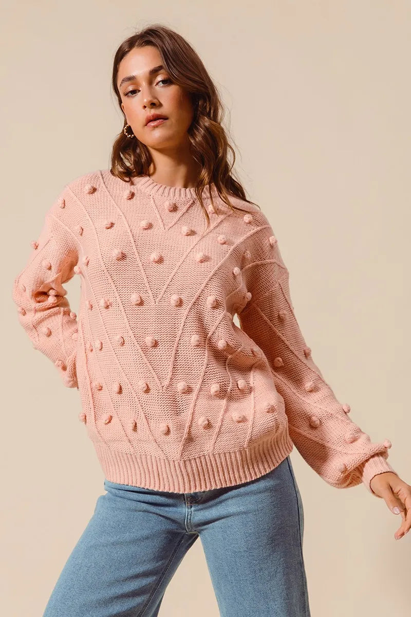 Blush pom-pom knit crewneck sweater with long sleeves and ribbed hem