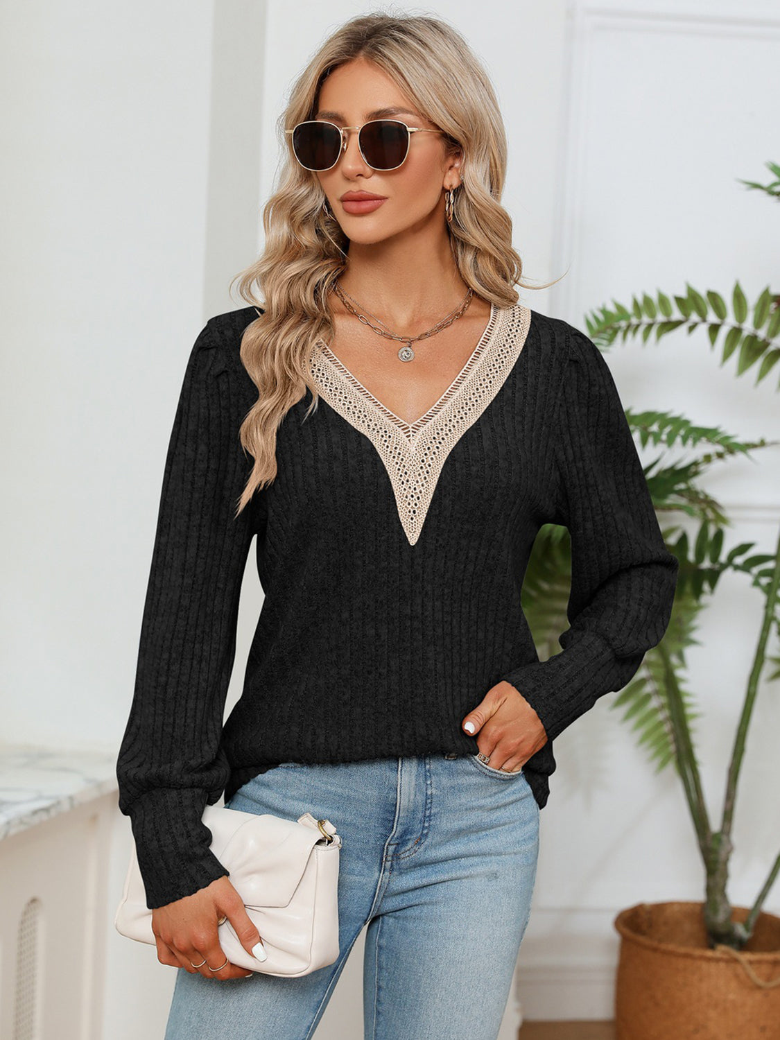 Black ribbed knit blouse with lace V-neck trim and long puff sleeves