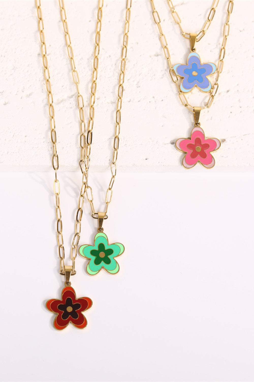 Gold chain flower pendant necklace set with blue, pink, green, and red enamel flowers