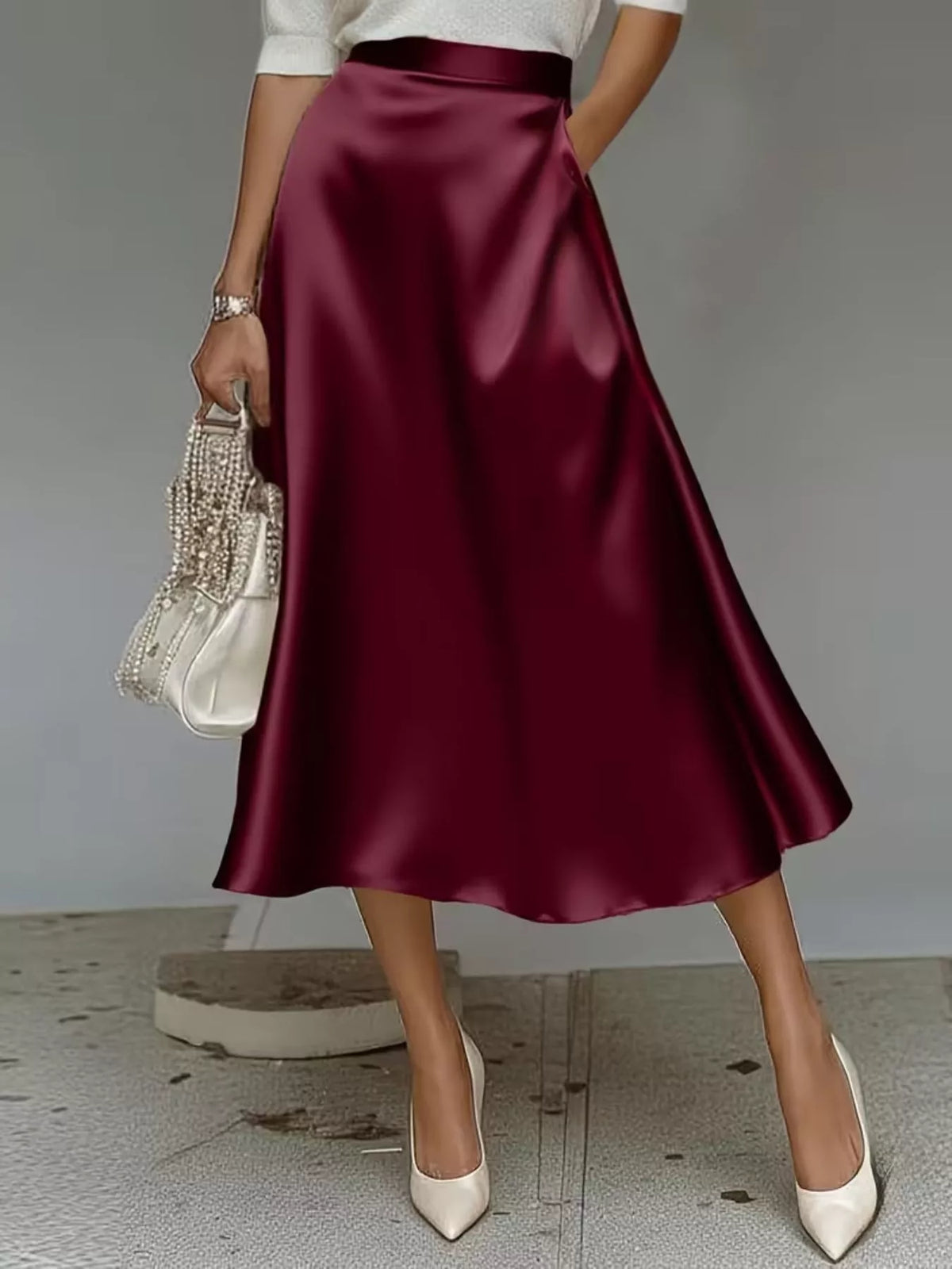 High-waist satin midi skirt in wine red, A-line silhouette and smooth sheen.