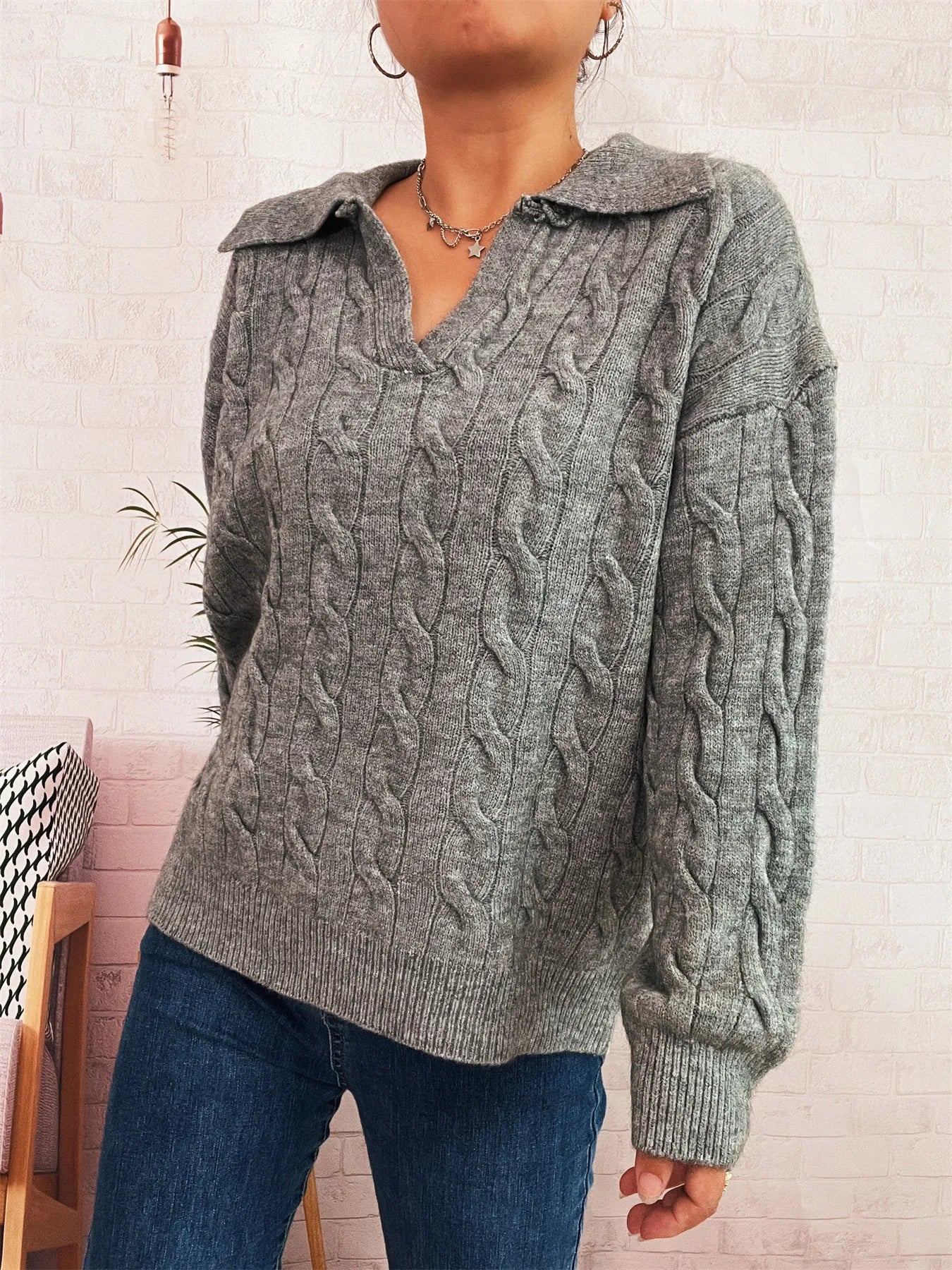 Gray cable-knit johnny-collar sweater with long sleeves, cable texture and relaxed fit.