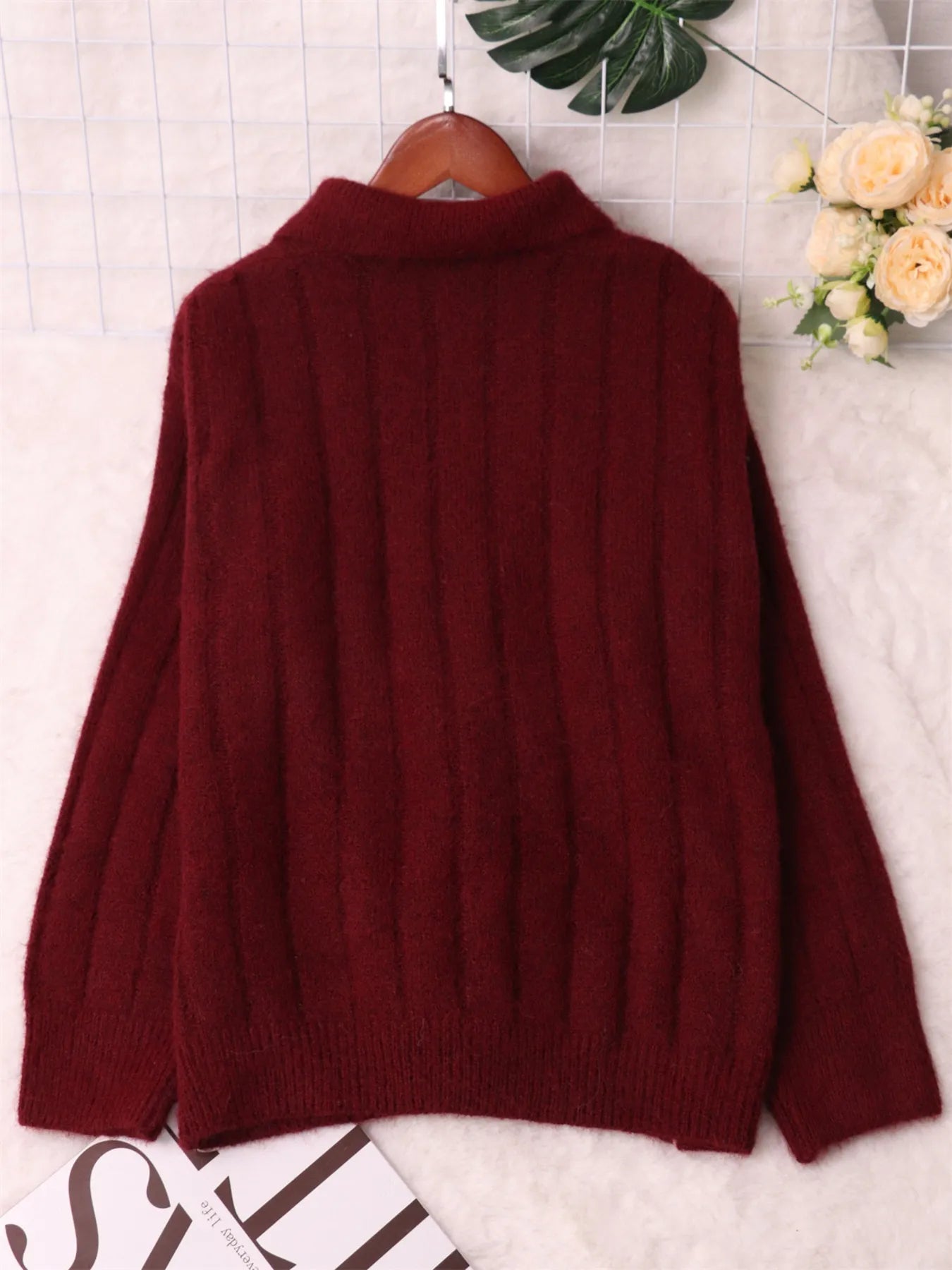 Ribbed hem quarter-zip sweater, burgundy back view on hanger with ribbed hem.