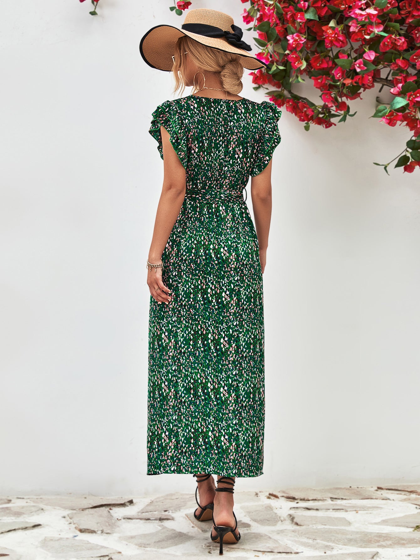 Green printed surplice neck flutter sleeve slit dress shown from back, midi length with V back detail.
