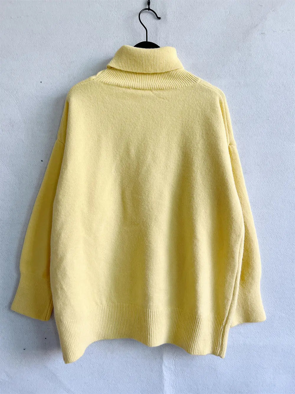 Yellow turtleneck long sleeve sweater on hanger, back view