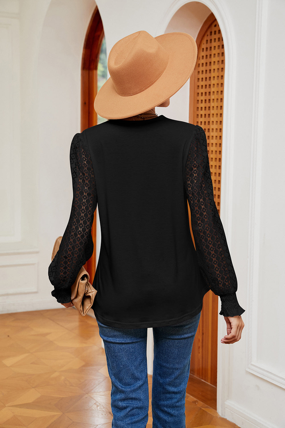 Black contrast V-neck blouse, back view, with sheer patterned sleeves and long cuffs