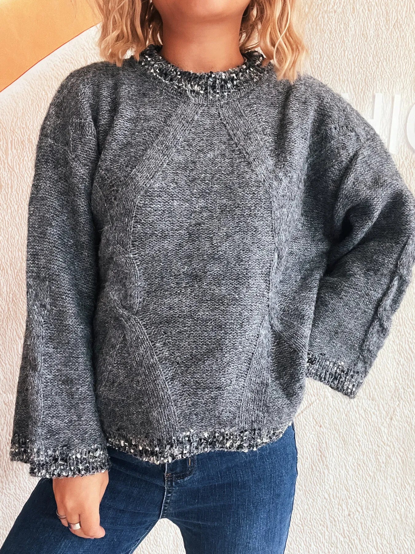 Dark gray round-neck sweater featuring contrast trim on neckline, cuffs, and bottom hem.