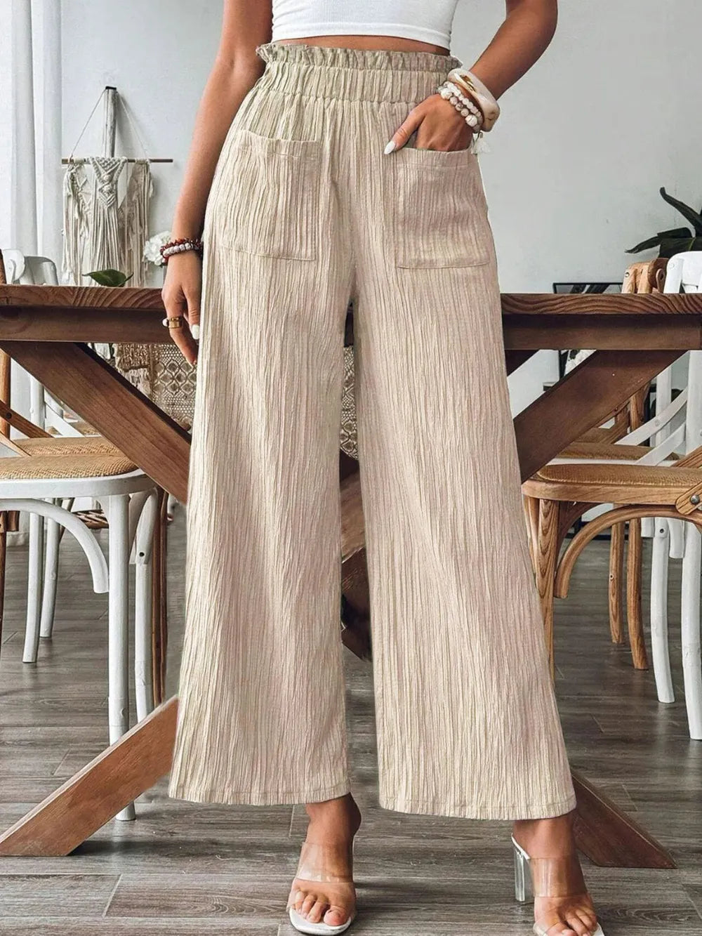 Tan wide-leg pants with elastic waistband and front patch pockets, textured fabric