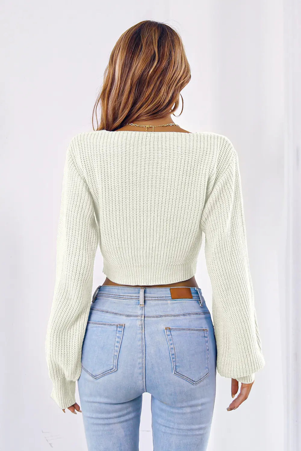 Cream knit bow V-neck cropped sweater, back view with ribbed cuffs