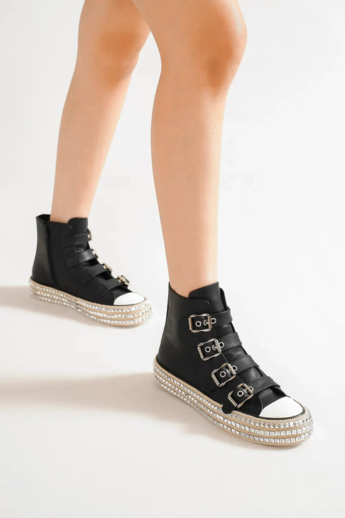 Black platform sneakers with multiple buckle straps and studded white toe