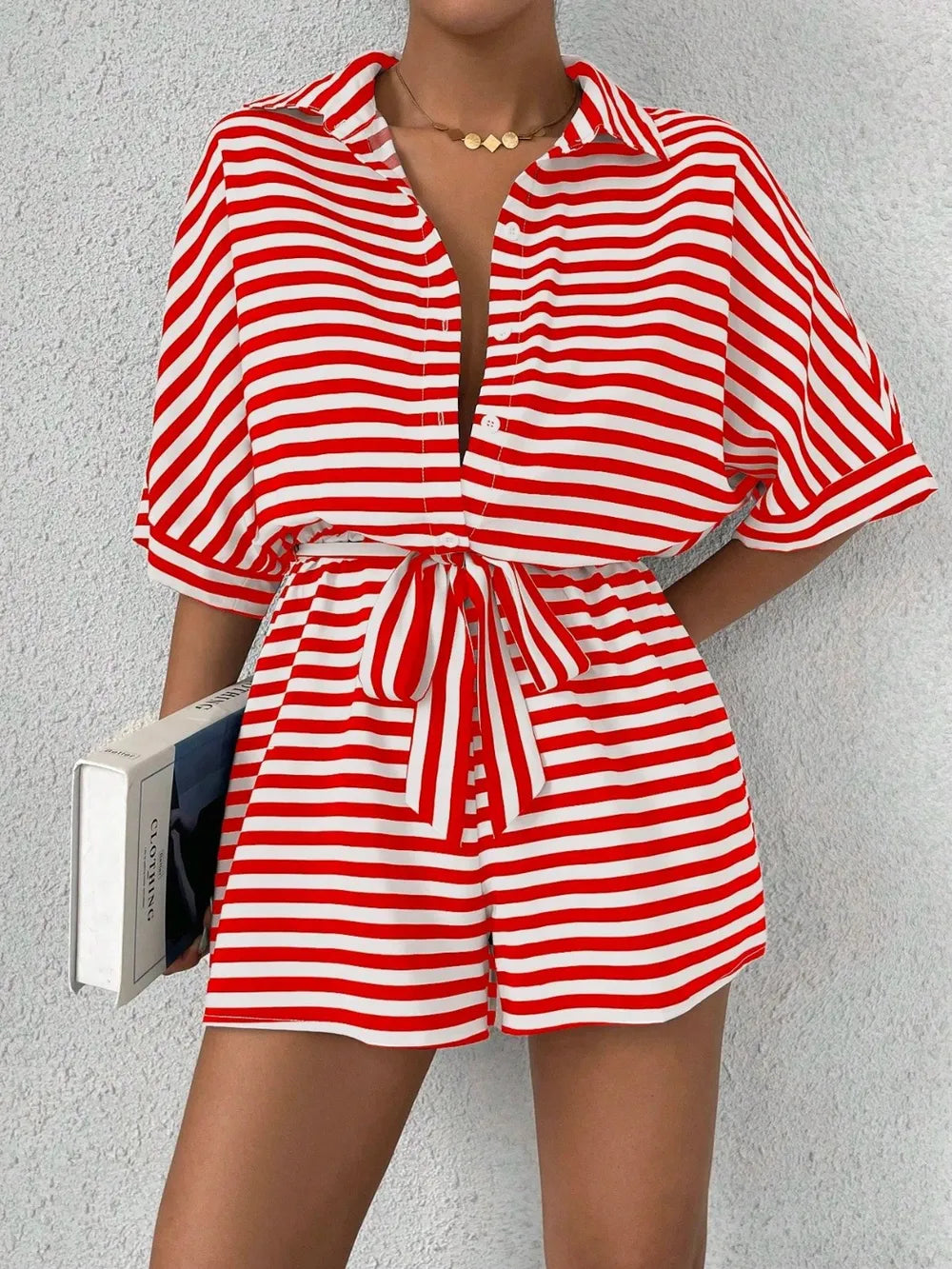 Red and white striped button-front romper with tie belt at waist and cuffed sleeves