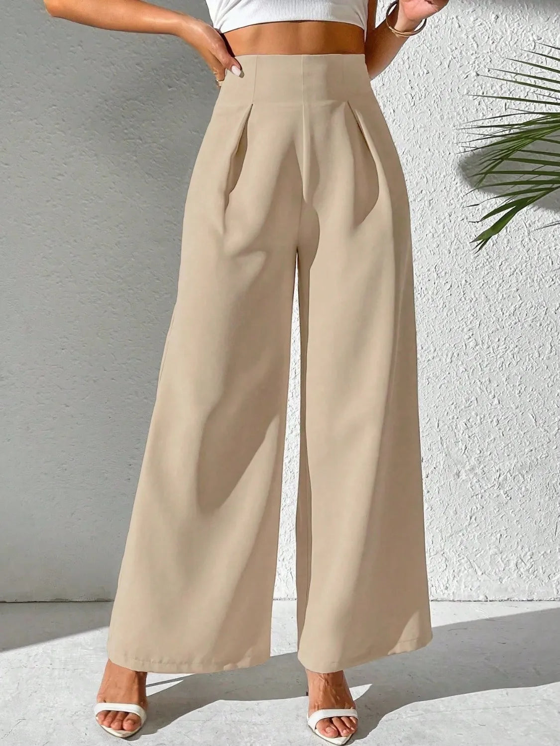 Tan wide-leg high-waist pants with pleated front and wide flowing legs