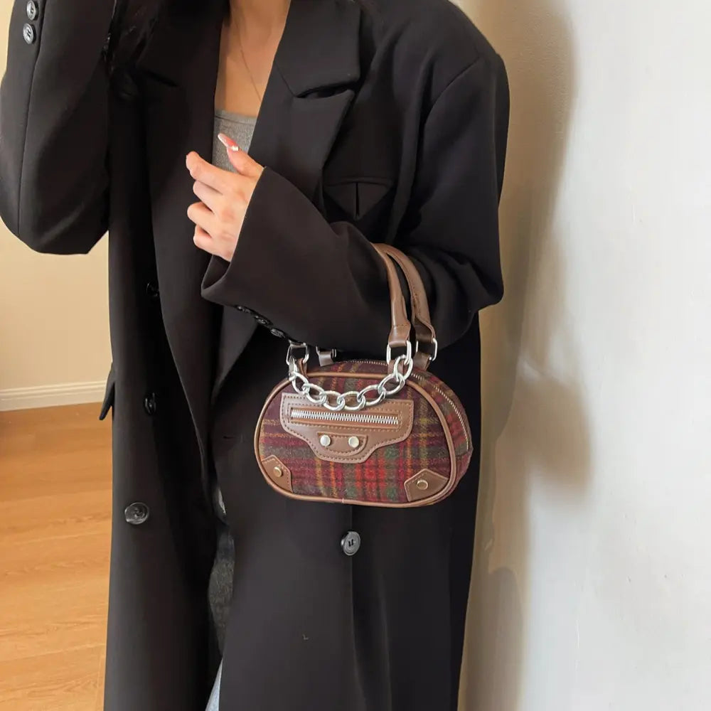 Brown plaid crossbody bag with front flap, grommet-style details, and chain strap