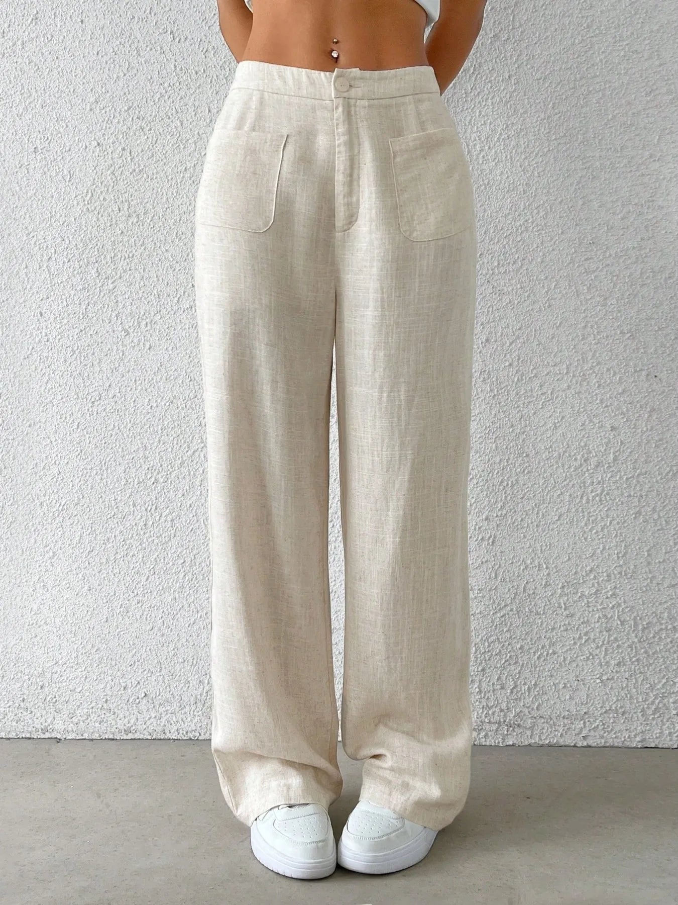 Beige wide-leg pants with front pleats, side pockets, and elastic waistband.