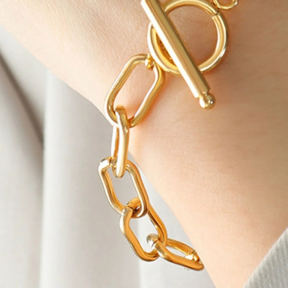 Gold-tone chain bracelet with heart-shaped charm and bar closure detail