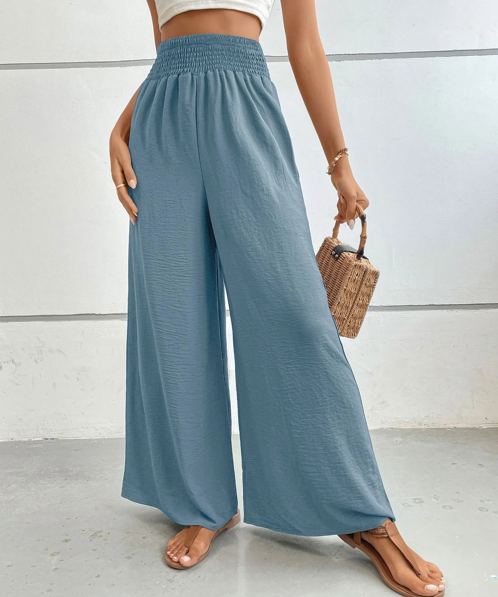 High-waisted wide-leg pants in dusty blue with smocked elastic waistband and flowing legs