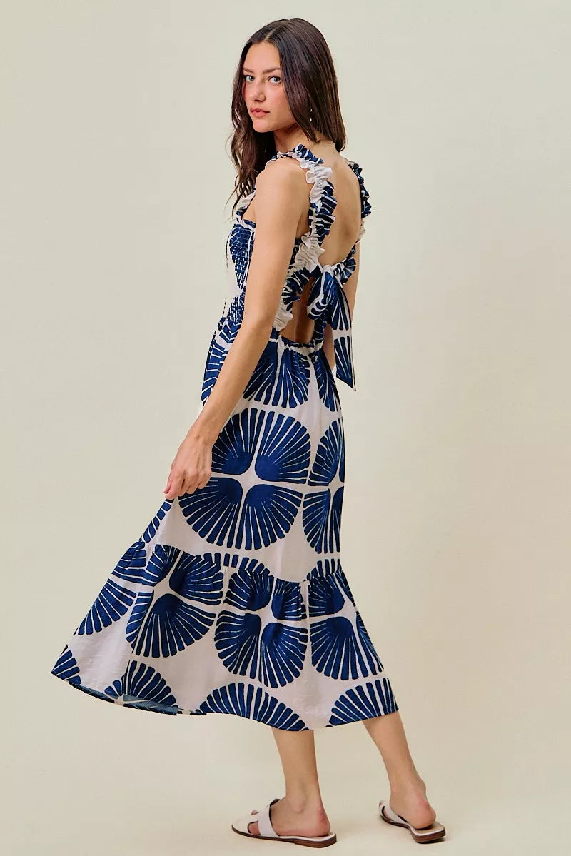 Side view of navy and white abstract print tiered midi dress with smocked bodice