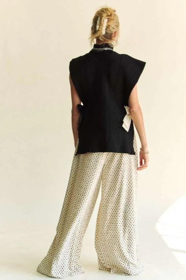 Black sleeveless knit turtleneck top viewed from back, with side slit