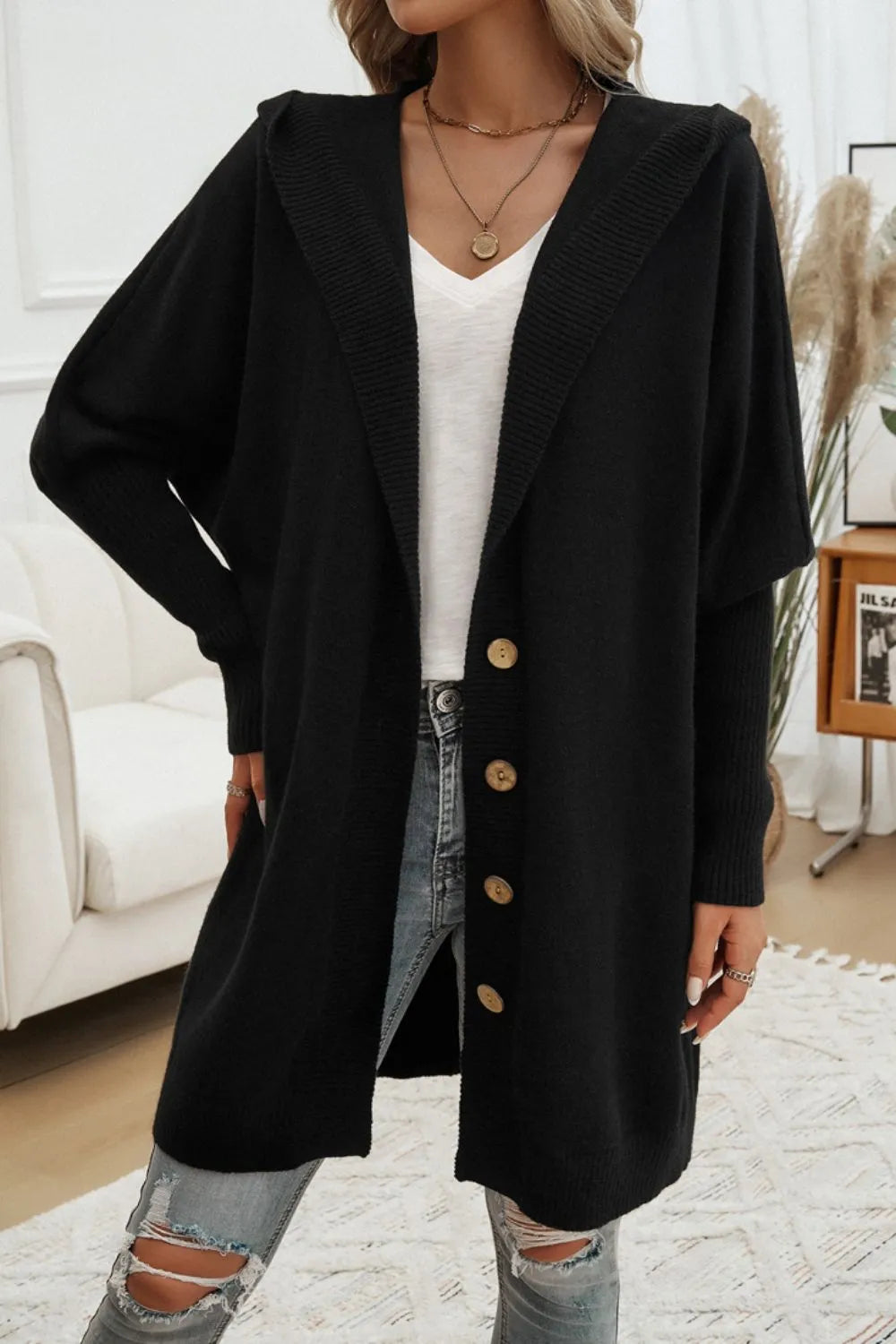Black hooded cardigan with long sleeves and front button placket, relaxed fit.