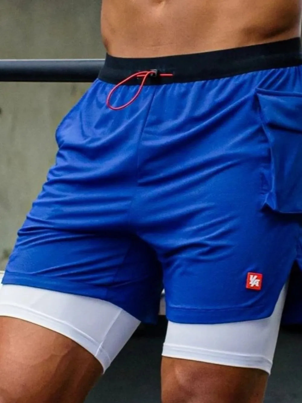 Royal blue drawstring shorts with black waistband, red drawcord, and white inner lining