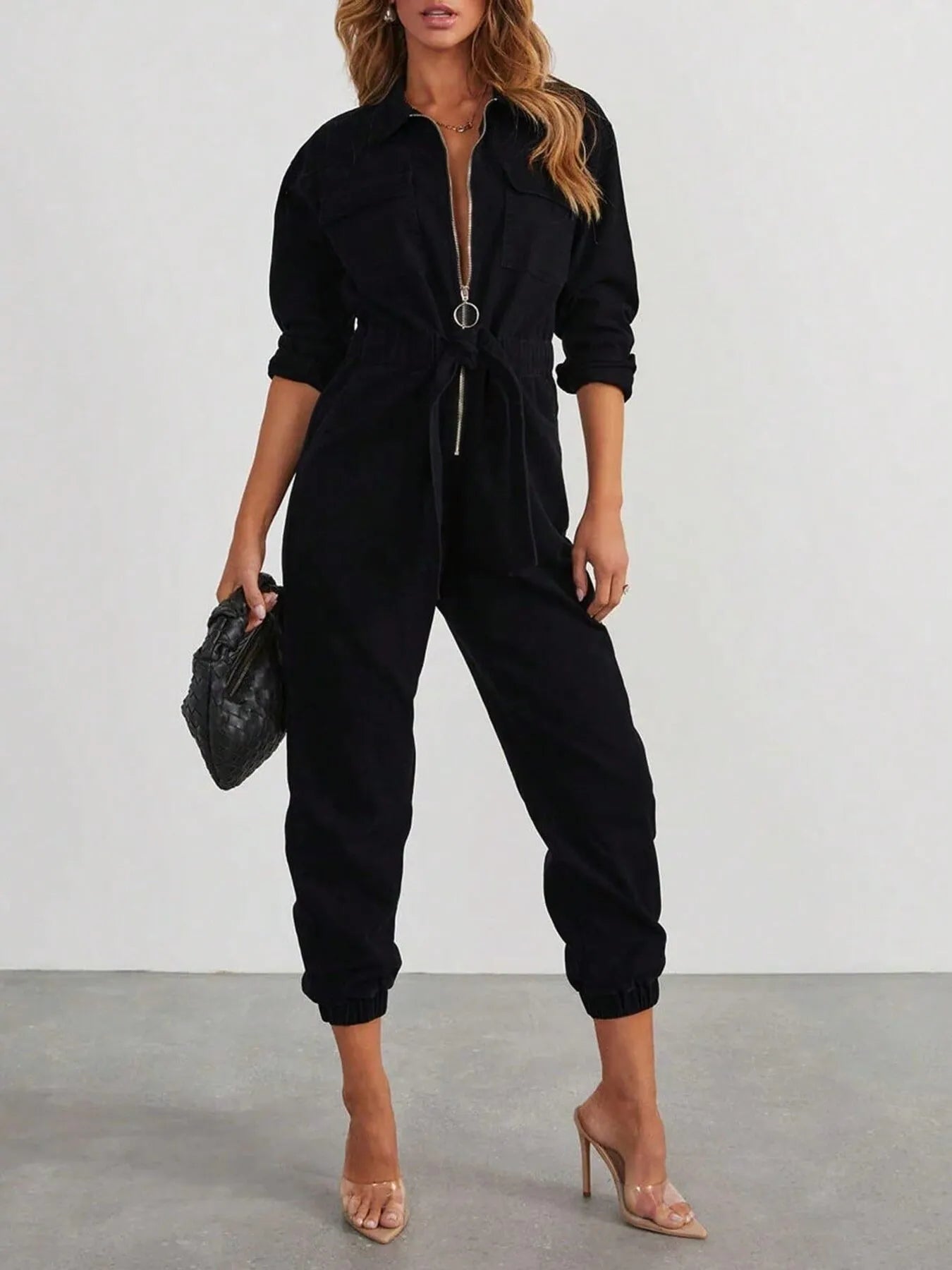 Black long-sleeve zip-front jumpsuit with drawstring waist and tapered cuffed legs