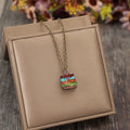 Gold-tone pendant necklace with small multicolor stacked book charm
