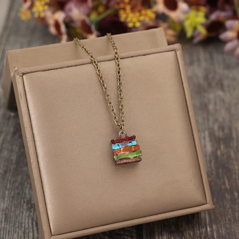 Gold-tone pendant necklace with small multicolor stacked book charm