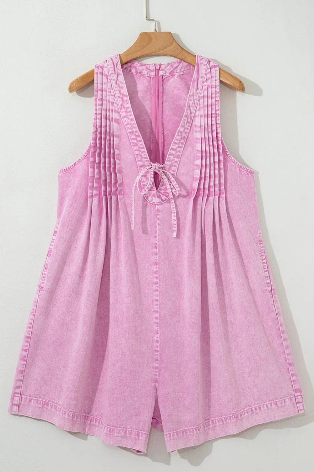 Pink mineral-wash sleeveless denim romper with pleated bust and tied neckline
