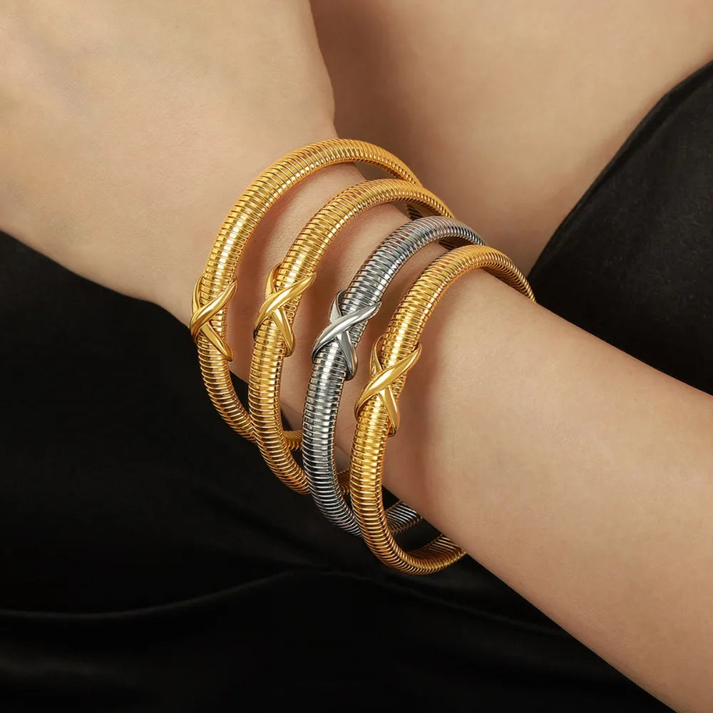 Gold and silver spring coil bracelet with twisted knot clasp on wrist