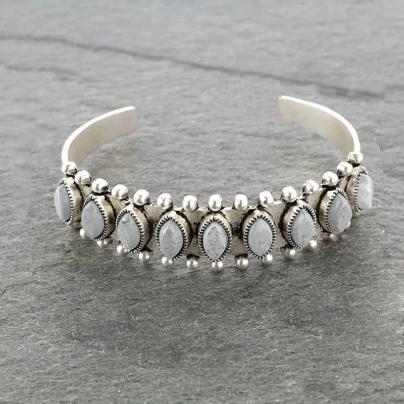 Open alloy bracelet with oval gray stones and silver bead trim on curved cuff