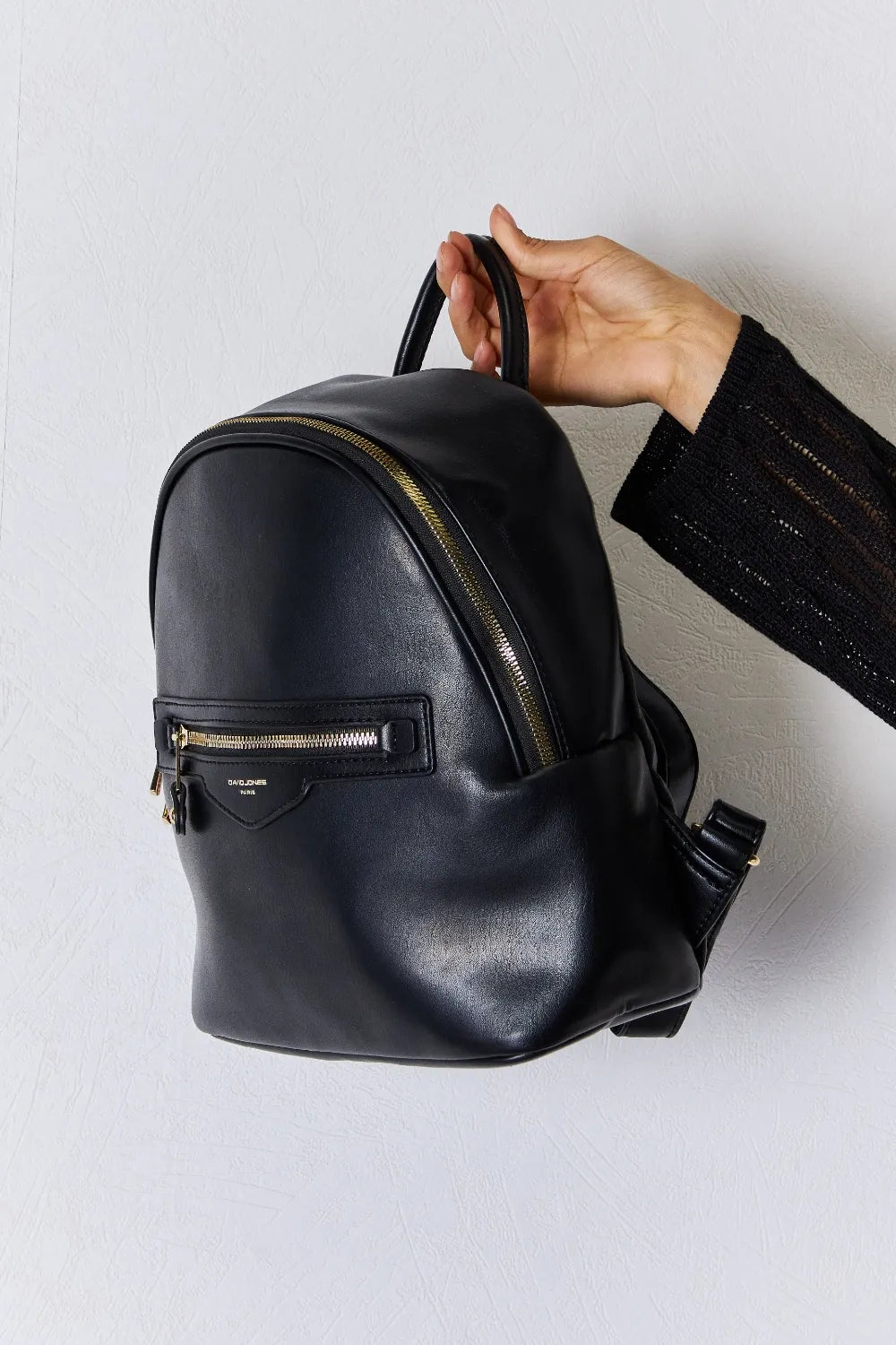 Black vegan leather mini backpack with side zipper and adjustable shoulder strap
