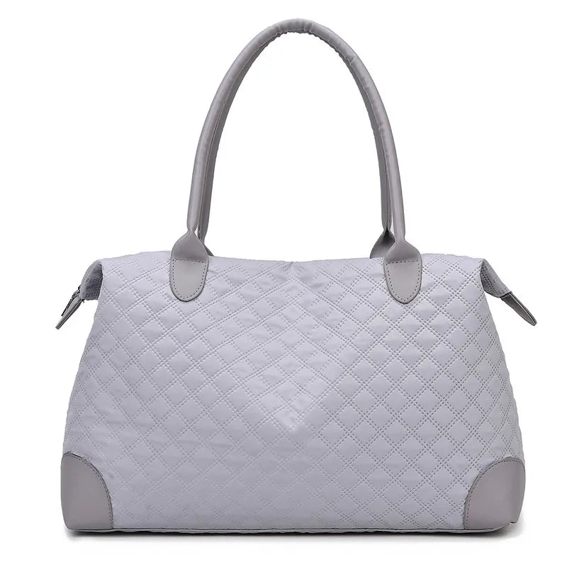 Gray quilted travel bag with top handles, side pulls, and zip closure
