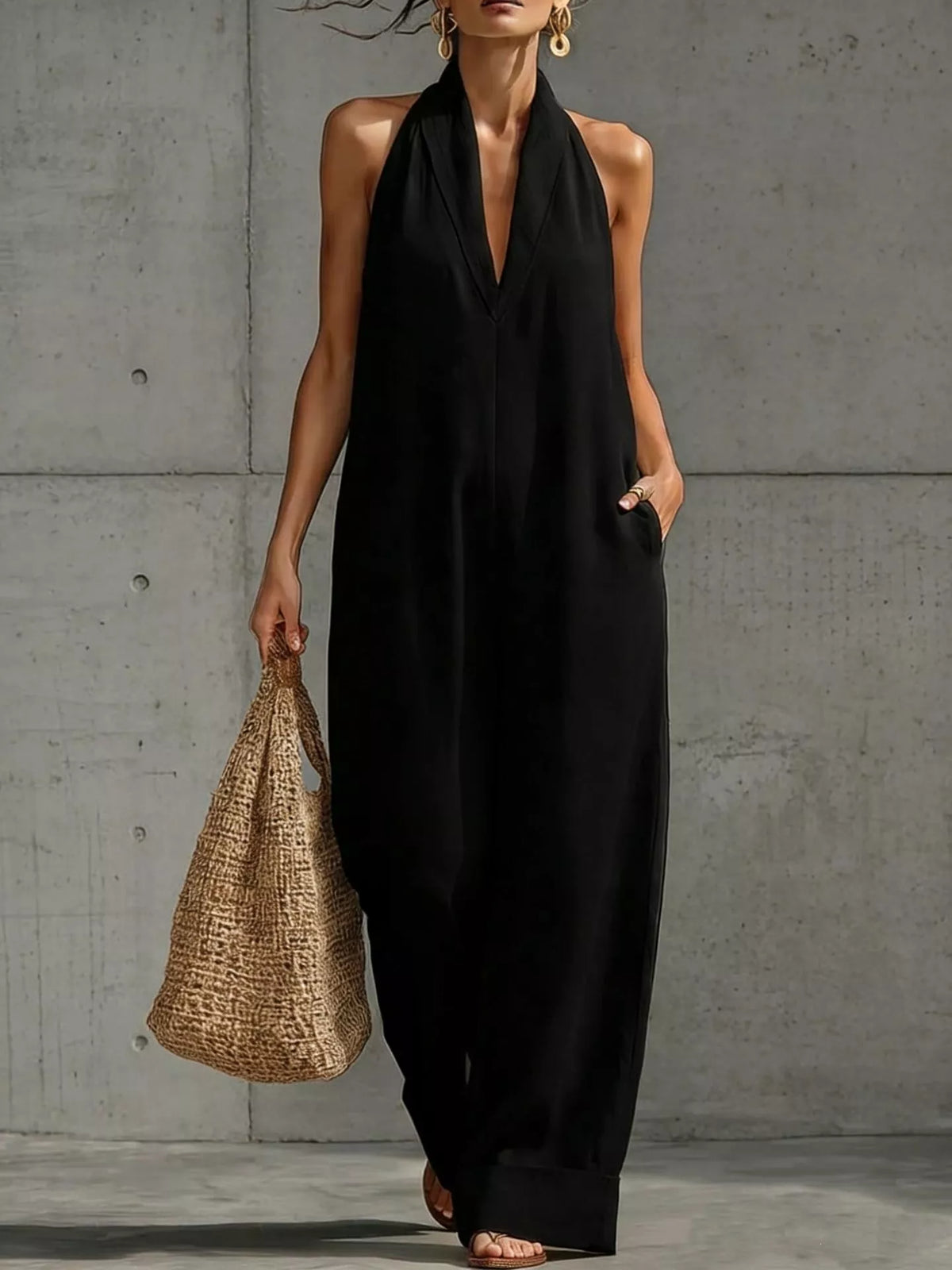 Black halter-neck wide-leg jumpsuit with deep V front and relaxed wide-leg silhouette, full length.