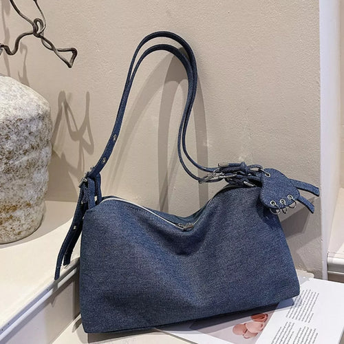 Dark blue denim shoulder bag with adjustable crossbody strap and tie fringe detail