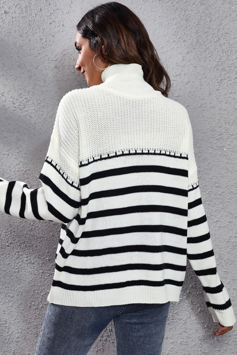 White knit turtleneck drop-shoulder sweater, back view, black striped band at the lower back