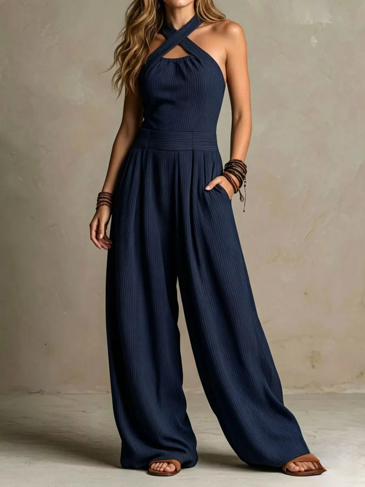 Navy crisscross halter wide-leg jumpsuit with pleated waist and full-length wide legs